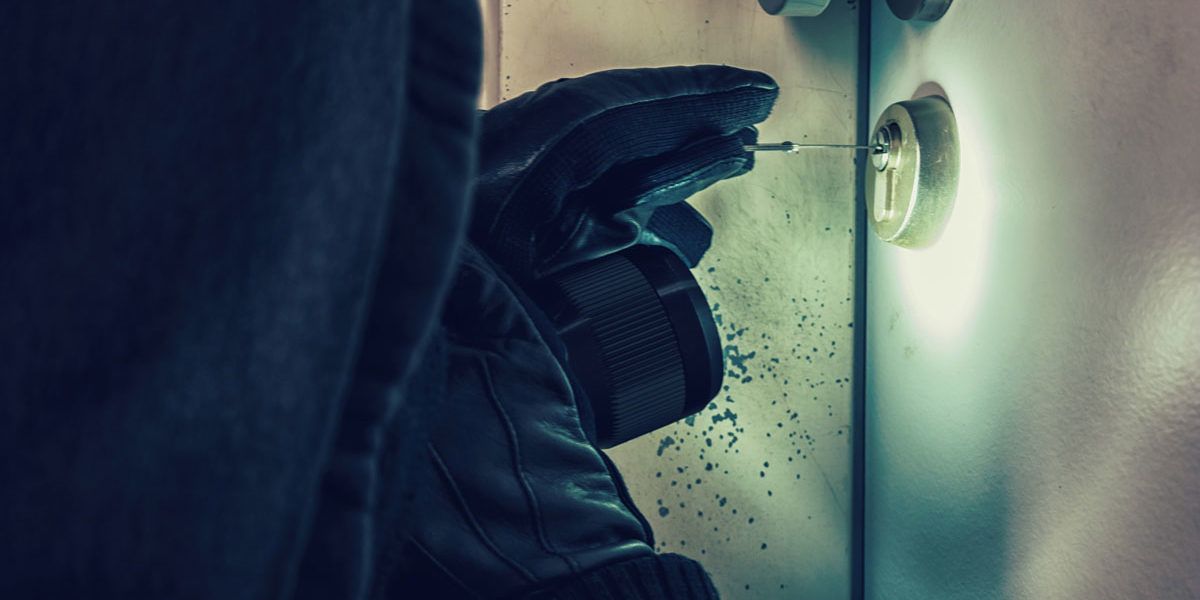 Einbrecher-beim-Tür-öffnen Einbrecher der eine Tür öffnet