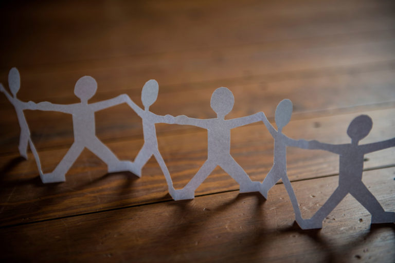 Papiermännchen die sich an den Händen fassen. Bildnachweis: complize / photocase.de