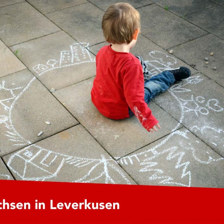 Kind malt mit Kreide am Boden Kind malt mit Kreide am Boden