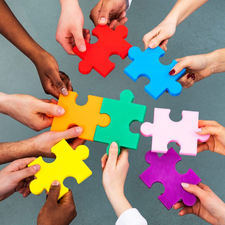 Hände mit Puzzleteilen